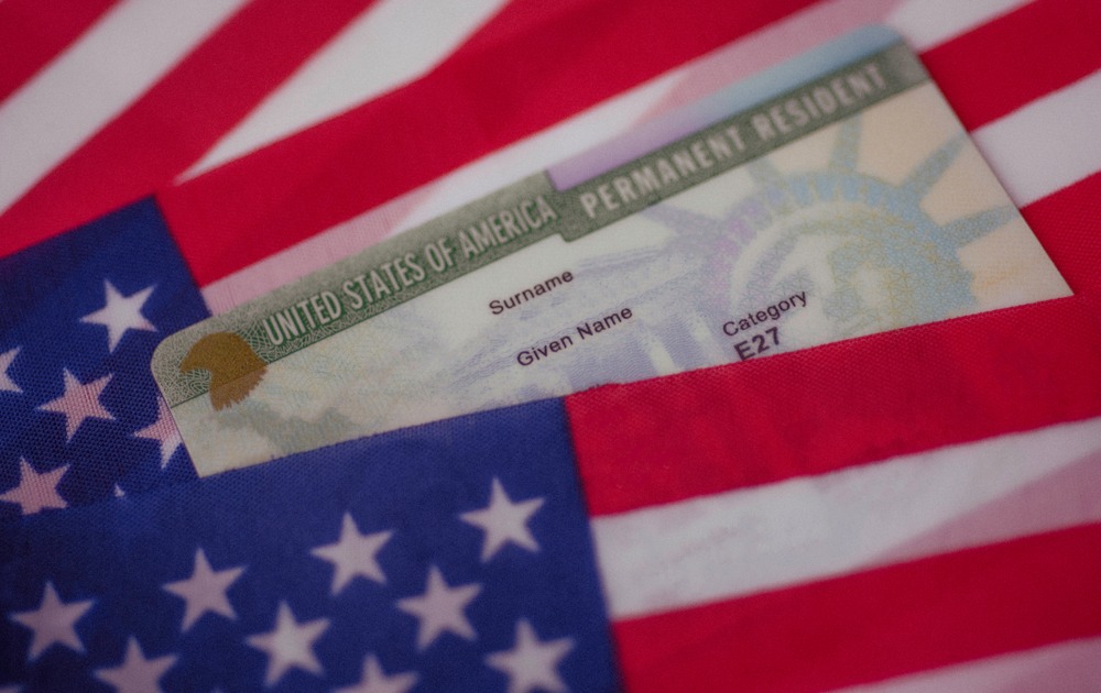 Green card covered by USA flag. What Are the Photo Requirements for a Green Card Application?