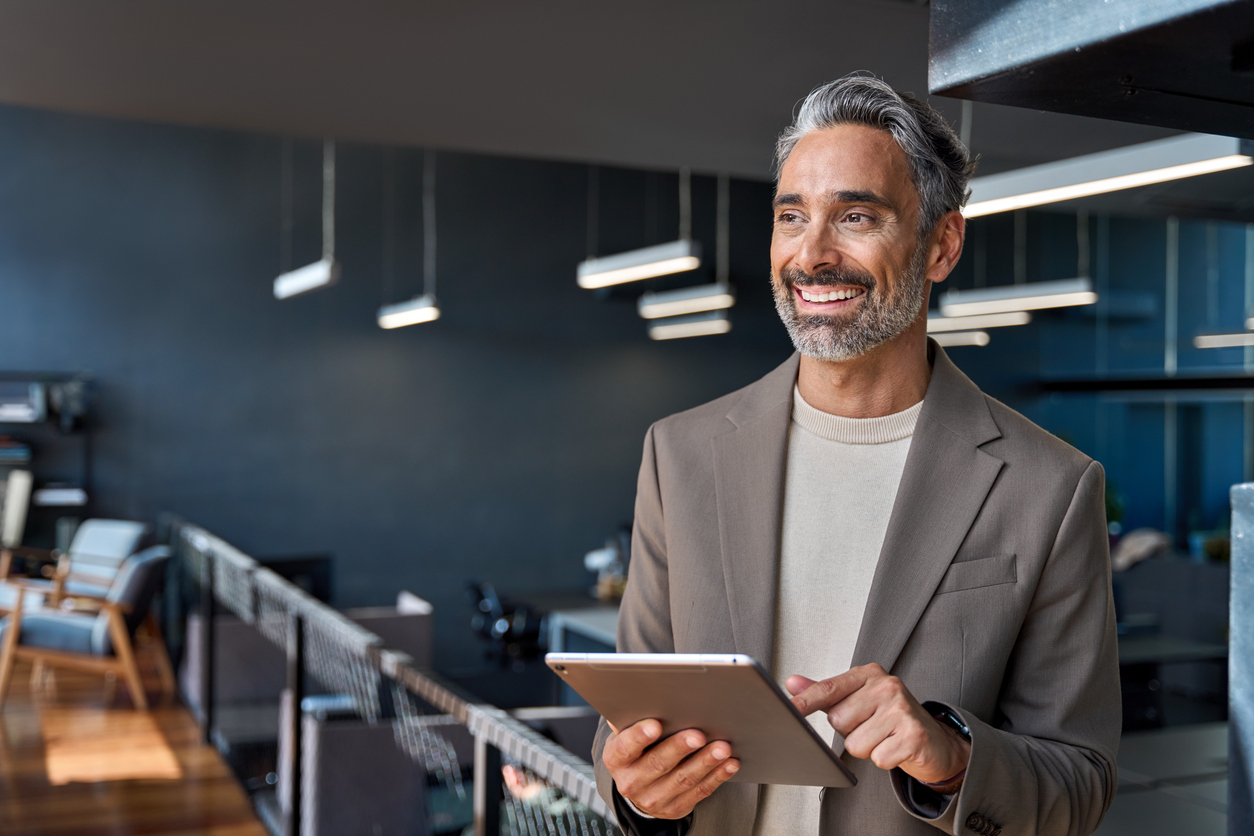 Smiling businessman holding a tablet in an office
