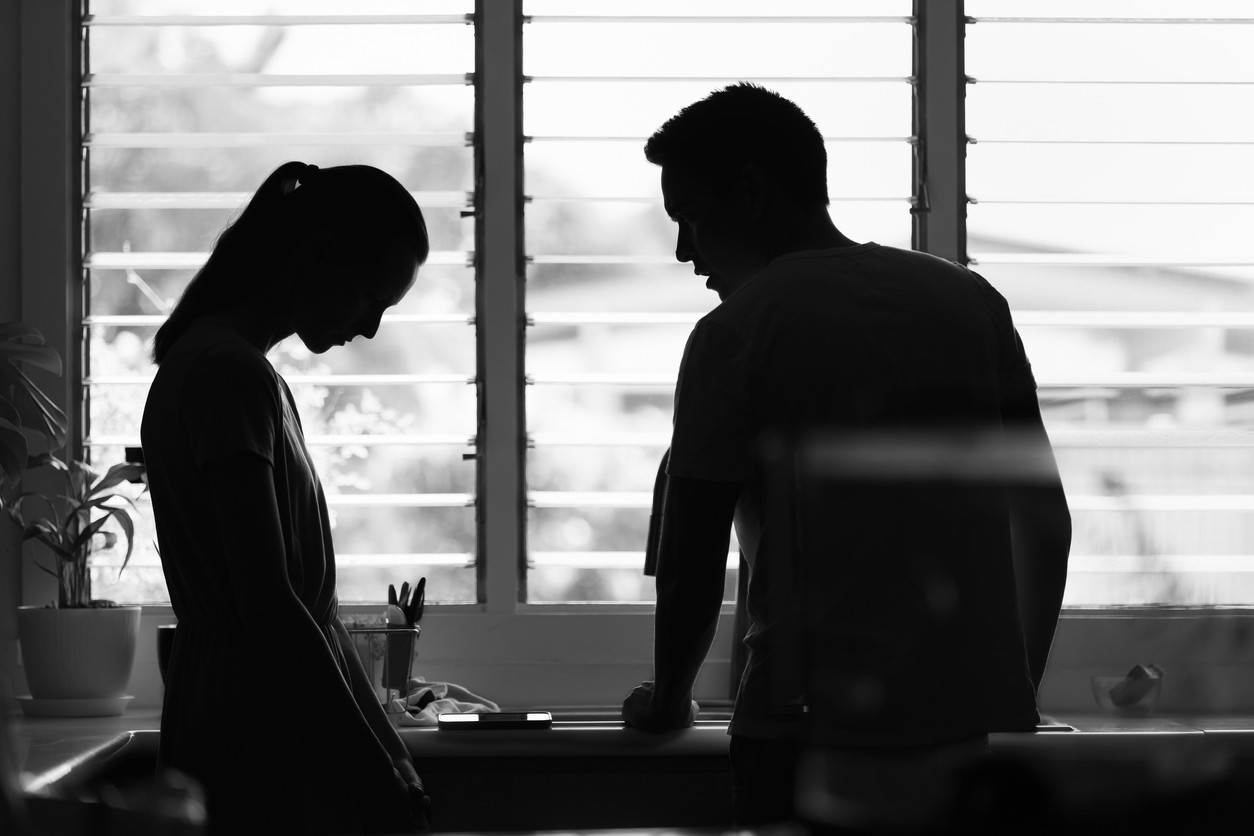 Silhouettes of a man and a woman who is looking sad