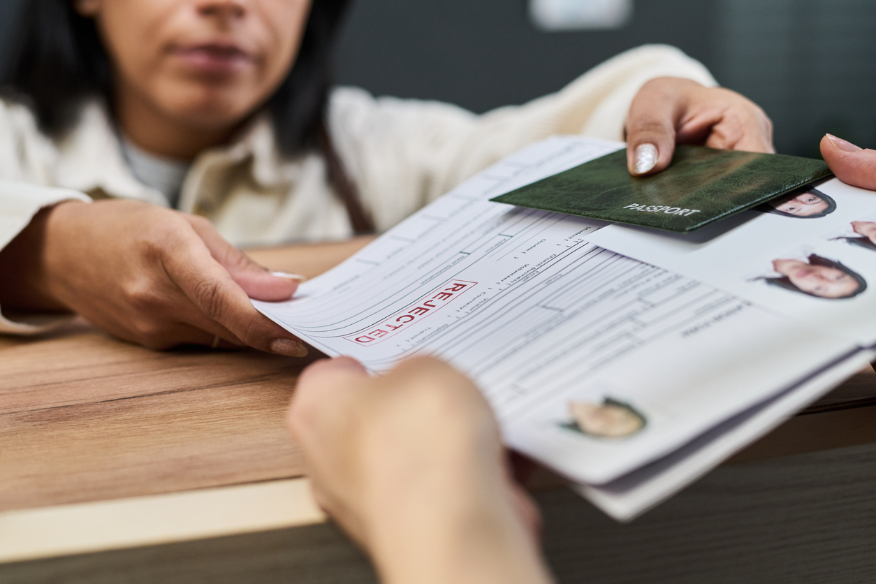 Woman handing over immigration documents to another person