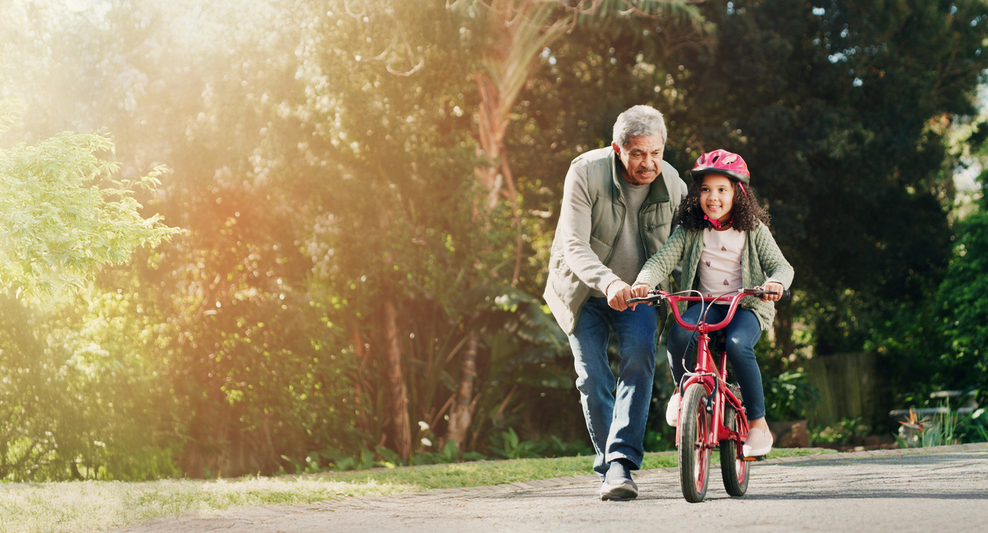 Grandfather helping a child riding a bike